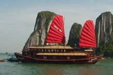 Travelers with Halong Bay on a traditional junk